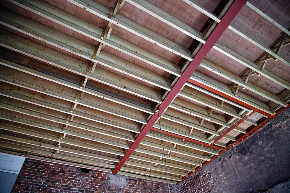 Rows of timber joists spanning between supporting beams inside a building during restoration